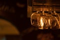 A few glass goblets for wine, martini, alcoholic drinks hang upside down above the bar. Warm evening yellow light, Royalty Free Stock Photo