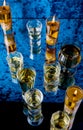 A few glasses of different sizes, filled with different whiskey shot on a mirror in a bar. Royalty Free Stock Photo