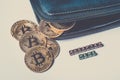 A few gold coins with the sign of bitcoin fell out of the purse and the inscription `accepted here`. Toned image