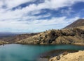 A few hikers on the banks of one of the Emerald Lakes high up on the Tongariro alpine crossing Royalty Free Stock Photo