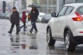 Rainy weather. Pedestrians on a pedestrian crosswalk in front of the car. Royalty Free Stock Photo