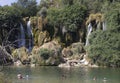 Few people taking a bath in the pool of Kravice waterfalls
