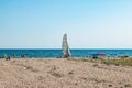 Few people on a wild beach in Zalizny Port Kherson region, Ukraine. One sailboat amid green grass, white sand and turquoise-blue