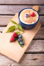 Few red and blue berries on chopping board with creamy dessert Royalty Free Stock Photo