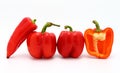 Few red ripe sweet peppers and one pepper in a cut on a light background. Royalty Free Stock Photo