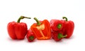 Few red ripe sweet peppers and one pepper in a cut on a light background. Royalty Free Stock Photo