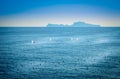 Few sailboats in sea and island in distance