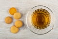 Few small biscuits, cup with tea on saucer on wooden table. Top view Royalty Free Stock Photo