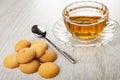 Few small biscuits, poon, transparent cup with tea on wooden table Royalty Free Stock Photo