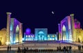 A few tourists on Registan square in Samarkand with Ulugbek madrasah, Sherdor madrasah and Tillya-Kari madrasah at moon night with