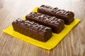 Wafers in chocolate on yellow paper napkin on wooden table Royalty Free Stock Photo