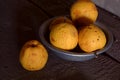 A few yellow wrinkled apples in an aluminum bowl