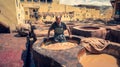 Man working as a tanner in the dye pots at leather tanneries at medina, Fez, Morocco. Royalty Free Stock Photo