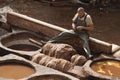 FEZ, MOROCCO - FEBRUARY 20, 2017: Man working within the paint holes at the famous Chouara Tannery in the medina of Fez. Royalty Free Stock Photo