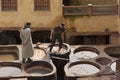 FEZ, MOROCCO - FEBRUARY 20, 2017: Men working within the paint holes at the famous Chouara Tannery in the medina of Fez. Royalty Free Stock Photo