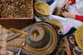 Fez, Morocco - top view of Argan oil stone handmill, box with seeds, female hands pounding nuts. Labor-intensive production.