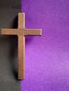 Lent Season, Holy Week, Good Friday, Easter Sunday Concept. Close up of wooden cross with black and purple colours background.