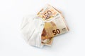 Ffp2 medical protection face mask against coronavirus filled with euro banknotes, concept for rising costs in health care or