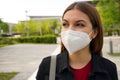 FFP2 protective mask. Close up of young woman wearing medical face mask in street as prevention and protection