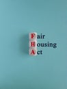FHA- FAIR HOUSING ACT symbol. Concept red words FAIR HOUSING ACT on wooden cubes. Beautiful blue background. Business concept. Royalty Free Stock Photo