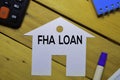 FHA Loan text on paper house isolated on office desk.