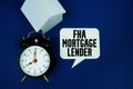 FHA Mortgage Lender text with alarm clock and house model on navy blue background Royalty Free Stock Photo