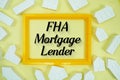 FHA Mortgage Lender text with house models on yellow background Royalty Free Stock Photo