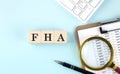 FHA word on wooden cubes on a blue background with chart and keyboard Royalty Free Stock Photo