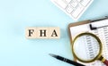 FHA word on wooden cubes on blue background with chart and keyboard Royalty Free Stock Photo