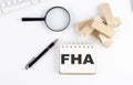 FHA word written on notebook with block magnifier and pen , business concept Royalty Free Stock Photo