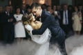 Fiance holds bride in his hands while dancing in the smoke Royalty Free Stock Photo