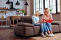 Stylish grandmother curiously looking at granddaughter engagement ring