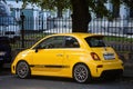 Fiat 500 Abarth parked in the street. Yellow small popular city car Royalty Free Stock Photo