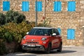 Fiat 500L car parked in front of a vintage wall with blue shutters