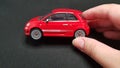 Fiat 500 red metal toy in two female fingers Royalty Free Stock Photo