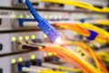 Fiber optic Patch-Cord is shown close-up in the server room of the data center. Optical Internet wire with laser light is on the