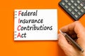 FICA symbol. Concept words FICA federal insurance contributions act on white note on beautiful orange background. Business FICA