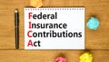 FICA symbol. Concept words FICA federal insurance contributions act on white note on beautiful wooden background. Business FICA Royalty Free Stock Photo