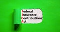 FICA symbol. Concept words FICA federal insurance contributions act on white paper on beautiful green background. Business FICA