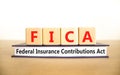 FICA symbol. Concept words FICA federal insurance contributions act on wooden block on beautiful white background. Business FICA