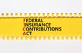FICA symbol. Concept words FICA federal insurance contributions act on yellow paper on beautiful white background. Business FICA