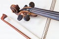 Fiddle bow and scroll on music book Royalty Free Stock Photo