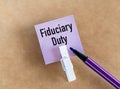 Fiduciary Daty text on a lilac card with a marker on a beige background