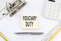 FIDUCIARY DUTY - business concept, message on the sticker on folder background with calculator