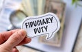 Fiduciary Duty text the a card in Hand. Finance and economics concept. Finance concept