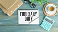 Fiduciary Duty. wooden light table. stationery.text on open notepad