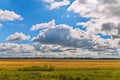 Field in the background of picturesque cumulus clouds