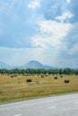 Field with bales of hay. Preparing hay for feeding animals. Newly beveled hay in bales on field Royalty Free Stock Photo