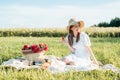 Field in daisies, a bouquet of flowers.French style romantic picnic setting. Woman in cotton dress and hat Royalty Free Stock Photo