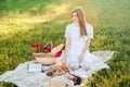 Field in daisies, a bouquet of flowers.French style romantic picnic setting. Woman in cotton dress and hat Royalty Free Stock Photo